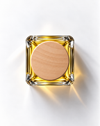 Green Horizon extrait de parfum from above: golden juice in a square glass bottle with a round wooden cap