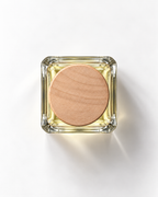 Velvet Skyline extrait de parfum from above: pale yellow juice in a square glass bottle with a round wooden cap