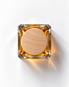 Vetiver Distillé extrait de parfum from above: amber juice in a square glass bottle with a round wooden cap